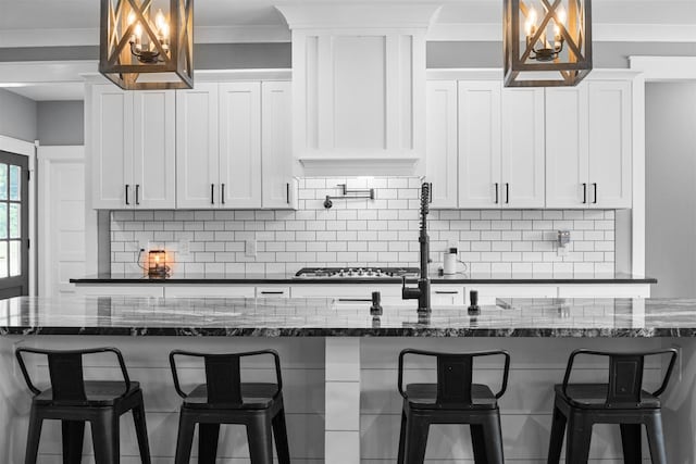 1014 Douglas Ct, Dickson, TN 37055 - kitchen featuring backsplash, white cabinetry, dark stone counters, and ornamental molding