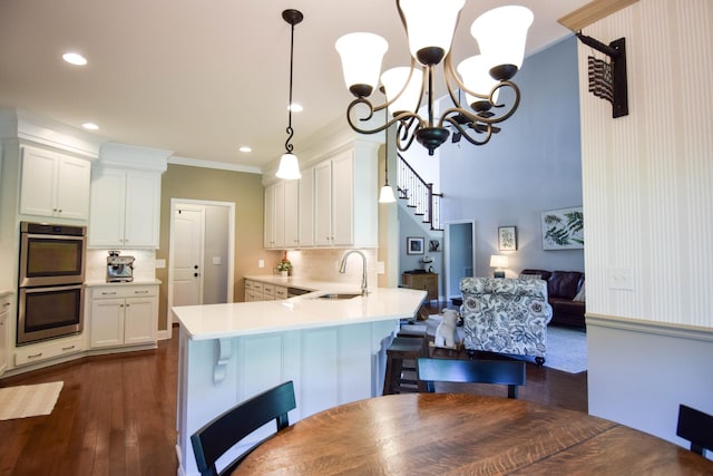 216 Honeysuckle Ln, Lebanon, TN 37087 - kitchen featuring double oven, crown molding, a chandelier, light countertops, and backsplash