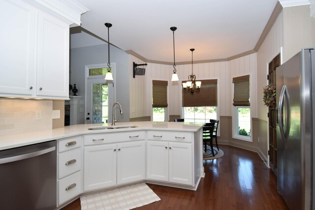 216 Honeysuckle Ln, Lebanon, TN 37087 - kitchen with stainless steel appliances, a chandelier, dark wood finished floors, a peninsula, and crown molding