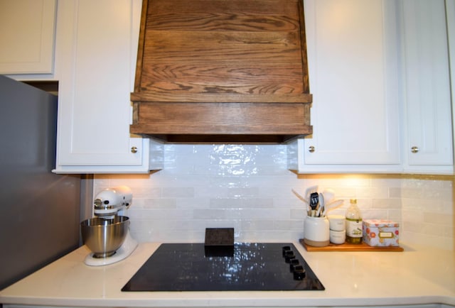 216 Honeysuckle Ln, Lebanon, TN 37087 - kitchen with custom exhaust hood, black electric cooktop, white cabinetry, light countertops, and decorative backsplash