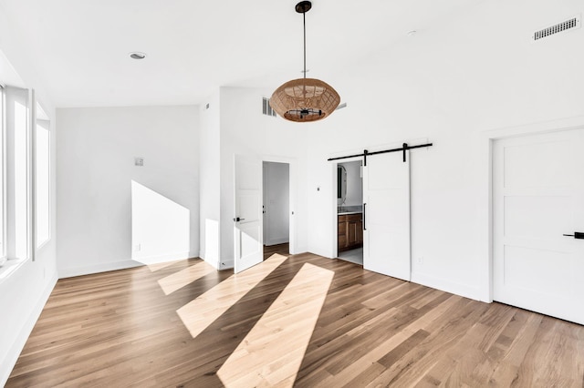 18 Willis St Unit A, Nashville, TN 37207 - unfurnished bedroom with a barn door, light wood-style flooring, and ensuite bathroom