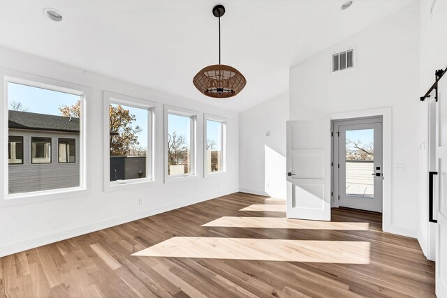 18 Willis St Unit A, Nashville, TN 37207 - unfurnished dining area with a barn door, wood finished floors, and high vaulted ceiling