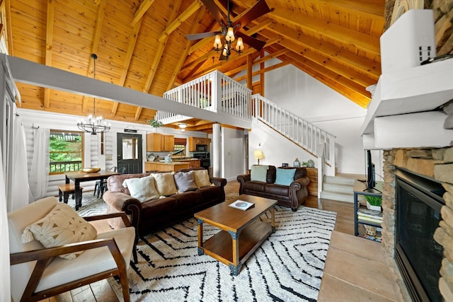 945 Scenic Trl, Gatlinburg, TN 37738 - living area featuring a chandelier, stairway, a stone fireplace, a ceiling fan, and high vaulted ceiling