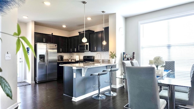 4289 Grapevine Loop, Smyrna, TN 37167 - kitchen with stainless steel appliances, light stone counters, backsplash, a breakfast bar area, and dark wood-style flooring