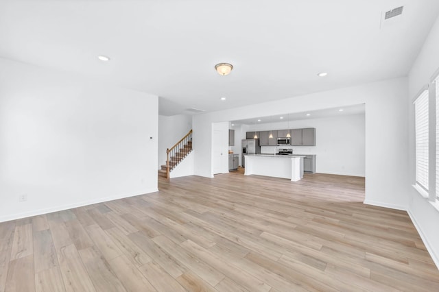 1234 English Oak Dr, Clarksville, TN 37043 - unfurnished living room featuring light wood-style floors, stairway, and recessed lighting
