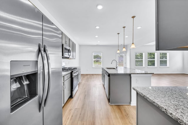 1234 English Oak Dr, Clarksville, TN 37043 - kitchen with appliances with stainless steel finishes, light wood-style flooring, light stone countertops, recessed lighting, and a kitchen island with sink