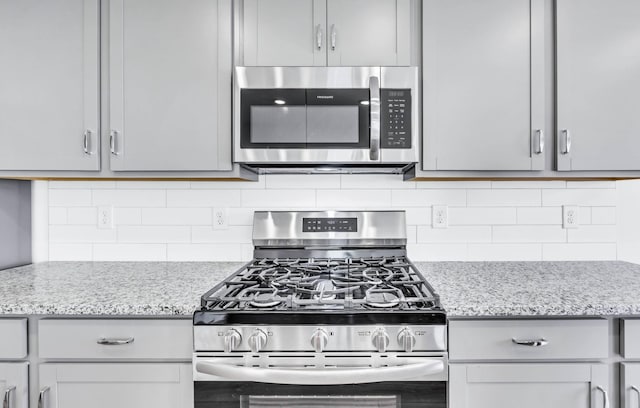 1234 English Oak Dr, Clarksville, TN 37043 - kitchen featuring appliances with stainless steel finishes, tasteful backsplash, and light stone counters
