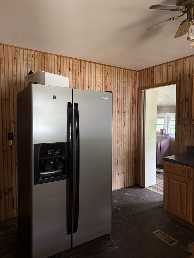 9843 Ed Lyell Rd, Lyles, TN 37098 - kitchen with stainless steel fridge with ice dispenser, ceiling fan, and wooden walls