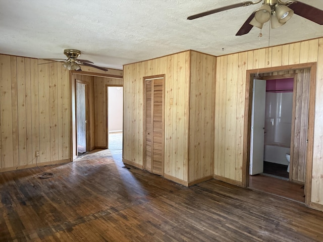 9843 Ed Lyell Rd, Lyles, TN 37098 - empty room with a ceiling fan, wood-type flooring, wood walls, and a textured ceiling