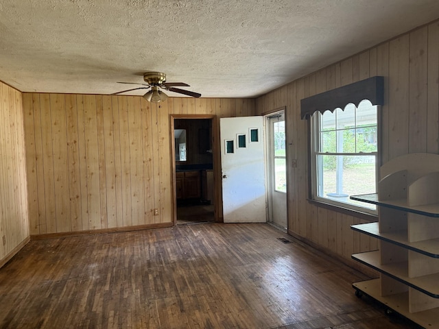 9843 Ed Lyell Rd, Lyles, TN 37098 - unfurnished dining area featuring hardwood / wood-style floors, a textured ceiling, ceiling fan, and wood walls