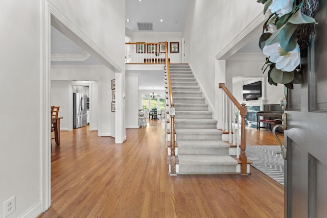 162 N Berwick Ln, Franklin, TN 37069 - entryway with stairs, a fireplace, wood finished floors, a high ceiling, and ornamental molding