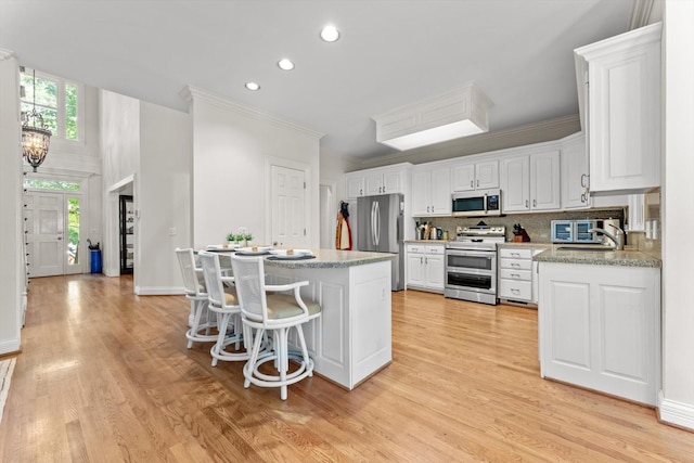 162 N Berwick Ln, Franklin, TN 37069 - kitchen with stainless steel appliances, light countertops, light wood-style floors, recessed lighting, and white cabinets