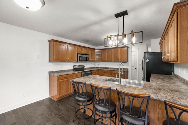 3158 Whitetail Dr, Clarksville, TN 37043 - kitchen with appliances with stainless steel finishes, a peninsula, brown cabinets, dark wood-type flooring, and a kitchen bar