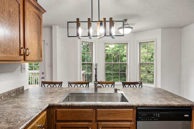3158 Whitetail Dr, Clarksville, TN 37043 - kitchen with dishwasher, dark countertops, brown cabinetry, a textured ceiling, and plenty of natural light