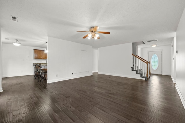 3158 Whitetail Dr, Clarksville, TN 37043 - unfurnished living room with a ceiling fan, stairs, dark wood-style floors, and a textured ceiling