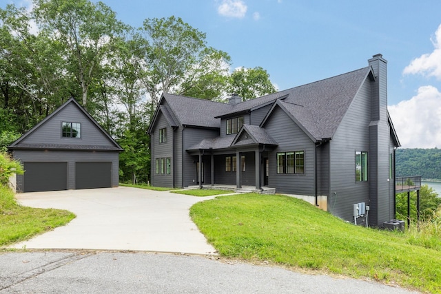 928 Harbor Pointe Dr, Silver Point, TN 38582 - view of front facade with a chimney, a detached garage, a shingled roof, and a front lawn