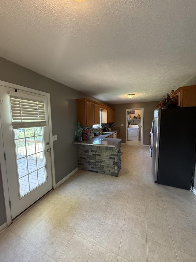 191 Lookout Cir, Trenton, GA 30752 - kitchen featuring stainless steel refrigerator with ice dispenser, a textured ceiling, light tile patterned floors, a peninsula, and brown cabinets