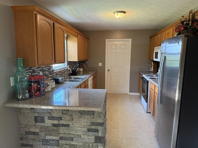 191 Lookout Cir, Trenton, GA 30752 - kitchen featuring white appliances, decorative backsplash, a peninsula, brown cabinets, and a textured ceiling