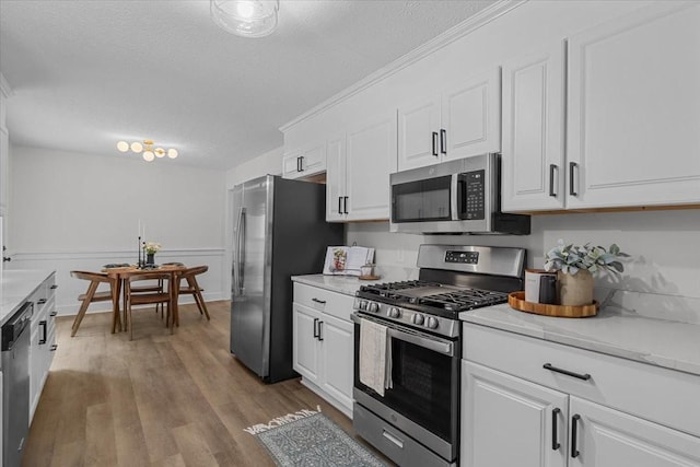 1122 Ridgecrest Dr, Dickson, TN 37055 - kitchen with stainless steel appliances, white cabinetry, light countertops, a textured ceiling, and ornamental molding