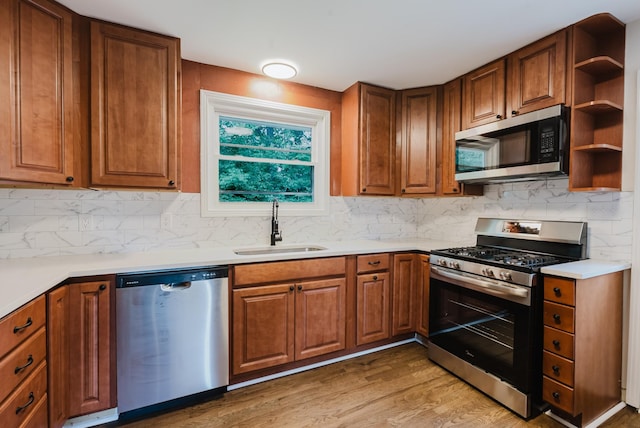 143 Bishop Ln, Burns, TN 37029 - kitchen with appliances with stainless steel finishes, light wood-type flooring, brown cabinetry, and backsplash