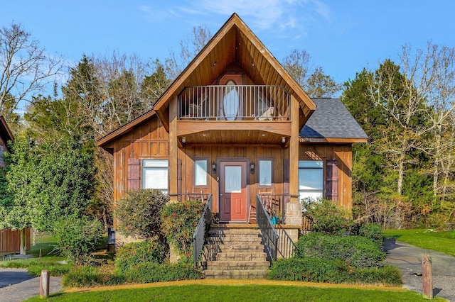 25 Bradley Ln, Bath Springs, TN 38311 - view of front facade with a balcony, roof with shingles, and board and batten siding