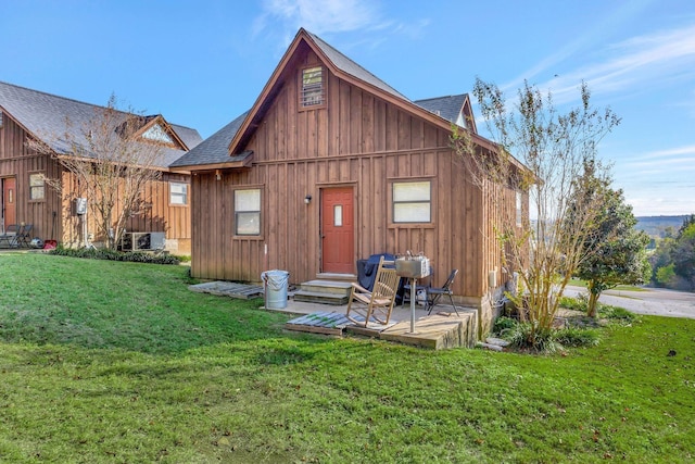 25 Bradley Ln, Bath Springs, TN 38311 - back of property with a shingled roof, board and batten siding, and a lawn