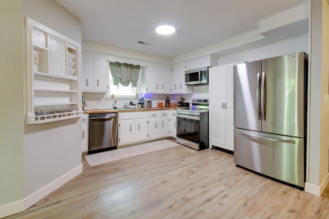 3150 Sugar Creek Rd, Woodlawn, TN 37191 - kitchen featuring appliances with stainless steel finishes, light wood finished floors, white cabinetry, light countertops, and open shelves
