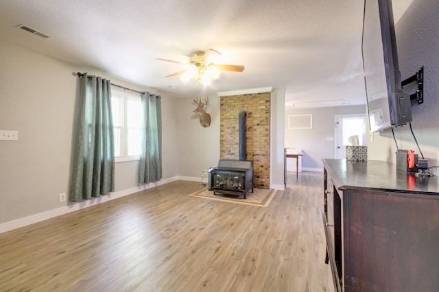 3150 Sugar Creek Rd, Woodlawn, TN 37191 - living room with a wood stove, ceiling fan, and light wood finished floors