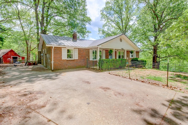 3150 Sugar Creek Rd, Woodlawn, TN 37191 - view of front of home featuring a chimney, covered porch, brick siding, a metal roof, and a standing seam roof