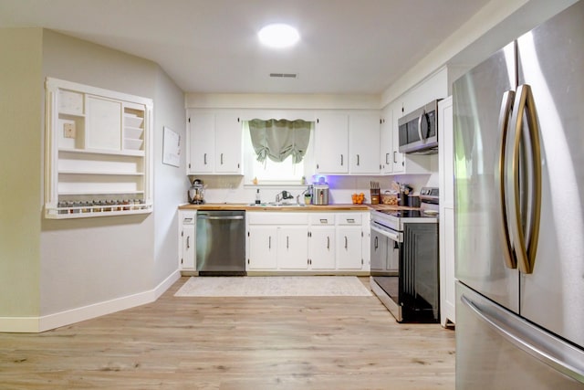 3150 Sugar Creek Rd, Woodlawn, TN 37191 - kitchen featuring appliances with stainless steel finishes, light wood-type flooring, and white cabinets