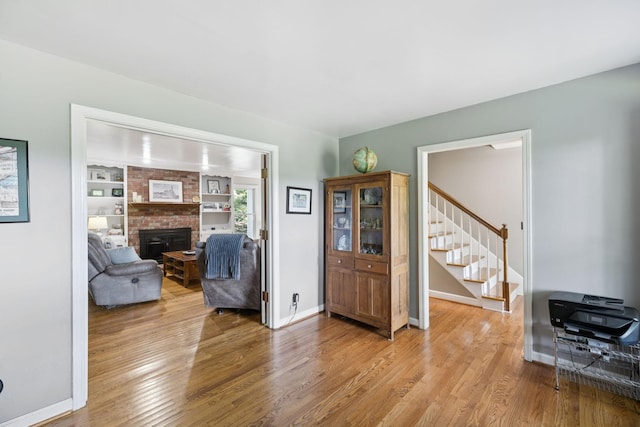 1201 Natchez Rd, Franklin, TN 37069 - living room with stairway, light wood-type flooring, a brick fireplace, and built in features