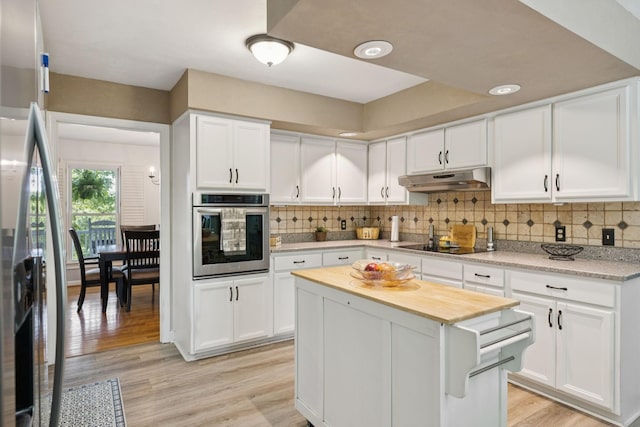 1201 Natchez Rd, Franklin, TN 37069 - kitchen featuring appliances with stainless steel finishes, under cabinet range hood, white cabinetry, and backsplash
