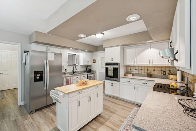 1201 Natchez Rd, Franklin, TN 37069 - kitchen with appliances with stainless steel finishes, wooden counters, ventilation hood, a center island, and light wood-style flooring