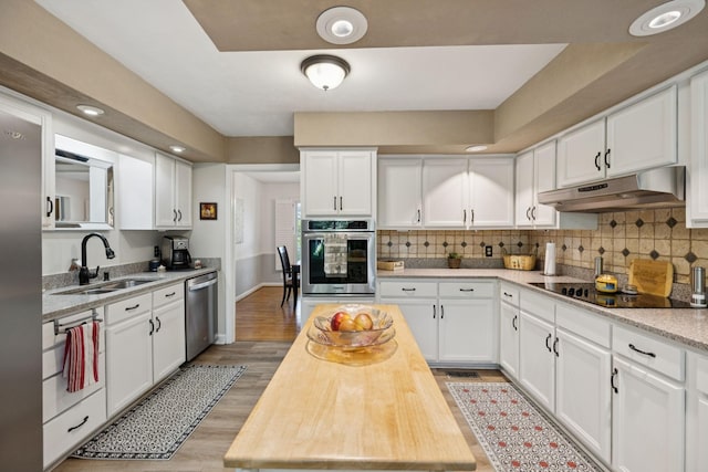 1201 Natchez Rd, Franklin, TN 37069 - kitchen featuring appliances with stainless steel finishes, under cabinet range hood, white cabinets, and decorative backsplash