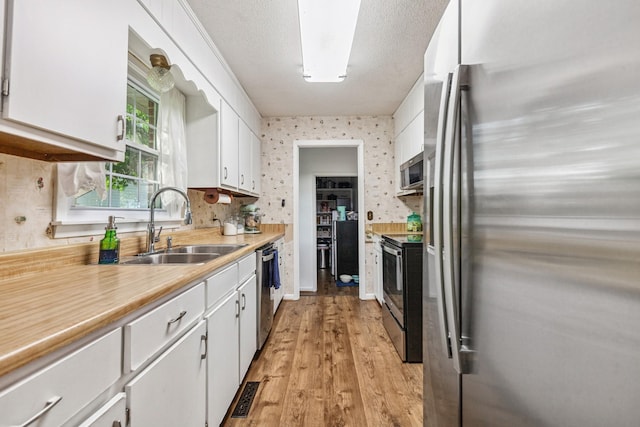 1150 Mattox Town Rd, Lawrenceburg, TN 38464 - kitchen with appliances with stainless steel finishes, white cabinetry, light countertops, and light wood-style flooring