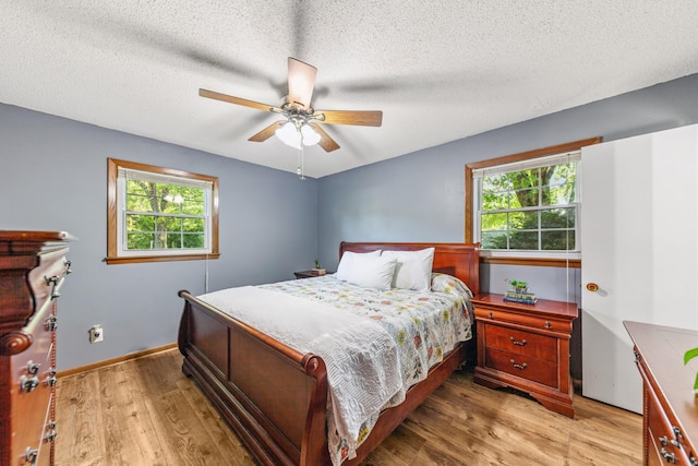 1150 Mattox Town Rd, Lawrenceburg, TN 38464 - bedroom with light wood-style flooring, multiple windows, a textured ceiling, and a ceiling fan