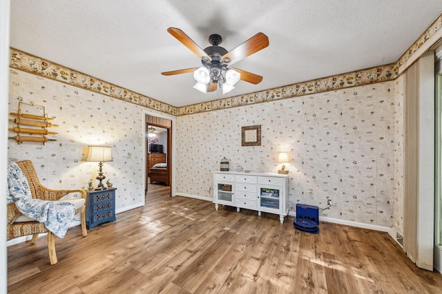 1150 Mattox Town Rd, Lawrenceburg, TN 38464 - unfurnished room featuring wallpapered walls, wood finished floors, a textured ceiling, and a ceiling fan