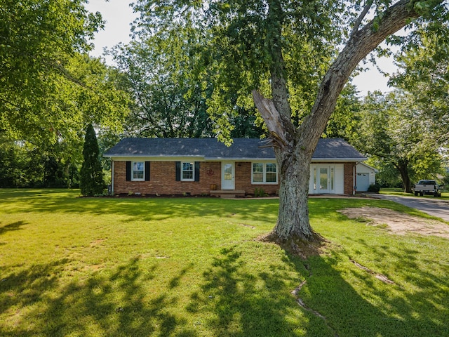 1150 Mattox Town Rd, Lawrenceburg, TN 38464 - single story home featuring brick siding, asphalt driveway, a front lawn, and french doors