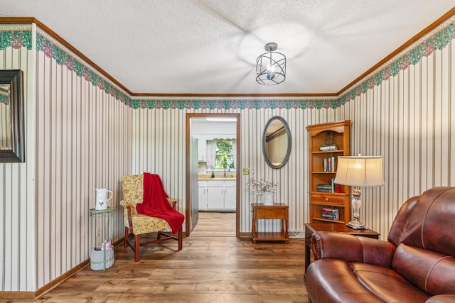 1150 Mattox Town Rd, Lawrenceburg, TN 38464 - sitting room featuring wood-type flooring, crown molding, a textured ceiling, and wallpapered walls