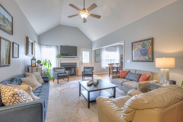 3307 Milton Ct, Thompsons Station, TN 37179 - living room featuring ceiling fan, vaulted ceiling, a fireplace with flush hearth, and light wood-style floors
