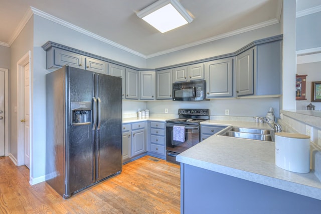 3307 Milton Ct, Thompsons Station, TN 37179 - kitchen featuring black appliances, gray cabinetry, light wood-type flooring, ornamental molding, and light countertops