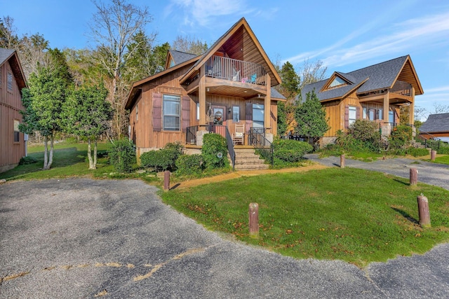 29 Bradley Ln, Bath Springs, TN 38311 - view of front facade with a balcony, a front lawn, and board and batten siding