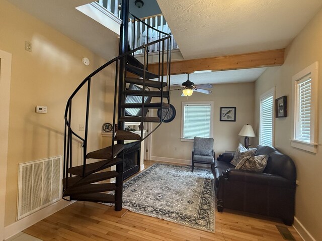 29 Bradley Ln, Bath Springs, TN 38311 - stairway featuring wood finished floors, beamed ceiling, and ceiling fan
