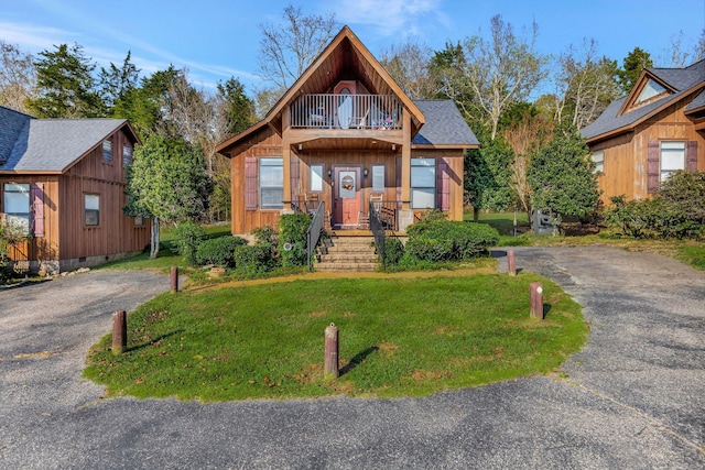 29 Bradley Ln, Bath Springs, TN 38311 - view of front facade with a balcony, a front lawn, asphalt driveway, and a shingled roof