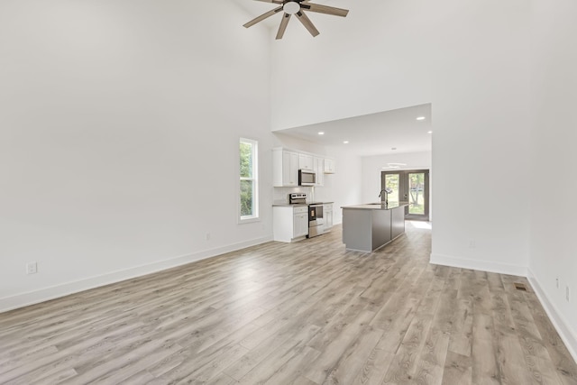 1111 W End Ave N, Lewisburg, TN 37091 - unfurnished living room with ceiling fan, light wood-style flooring, recessed lighting, and a towering ceiling