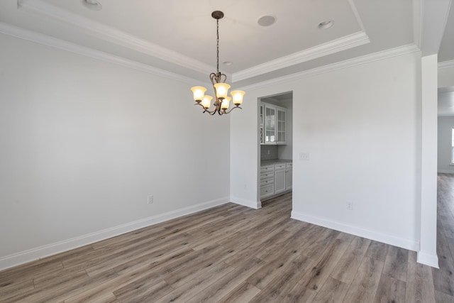 2039 Friendship Dr, Spring Hill, TN 37174 - empty room featuring a tray ceiling, wood finished floors, a chandelier, and crown molding