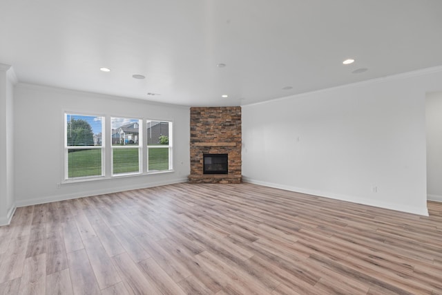 2039 Friendship Dr, Spring Hill, TN 37174 - unfurnished living room with ornamental molding, light wood-type flooring, a stone fireplace, and recessed lighting