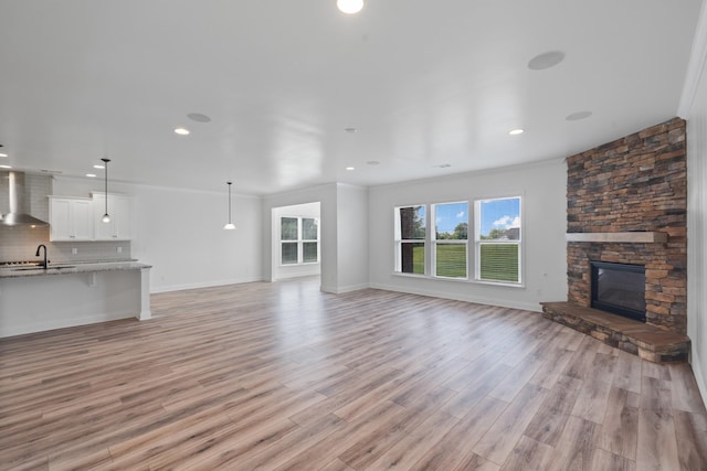 2039 Friendship Dr, Spring Hill, TN 37174 - unfurnished living room with light wood-type flooring, a fireplace, recessed lighting, and ornamental molding