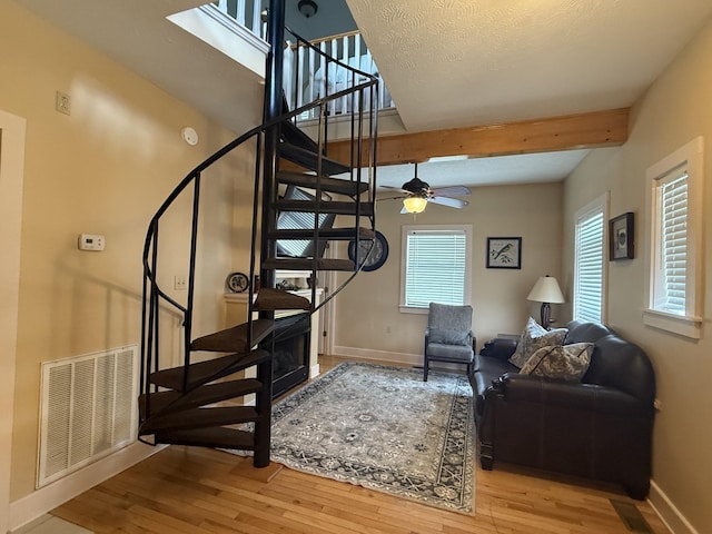 31 Bradley Ln, Bath Springs, TN 38311 - staircase featuring wood finished floors, beam ceiling, and a ceiling fan