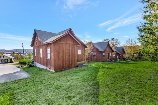 31 Bradley Ln, Bath Springs, TN 38311 - view of side of property featuring roof with shingles and a yard
